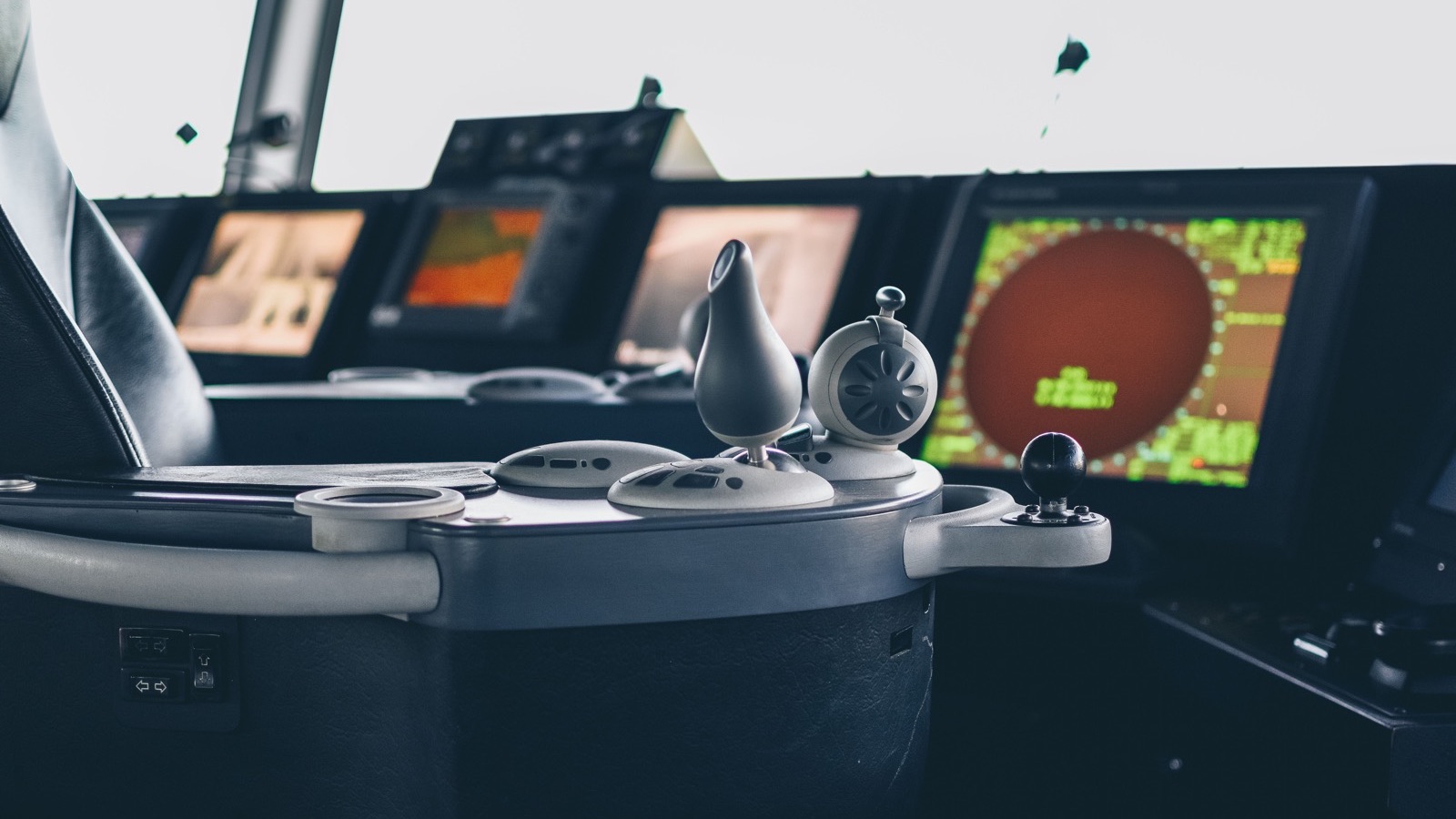 A navigation and radar console in a dark operations room